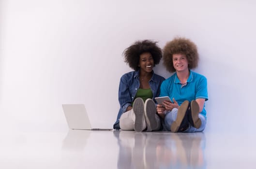 startup business and new mobile technology concept with young multiethnic couple in modern bright office interior working on laptop and tablet computer on new creative project and brainstorming