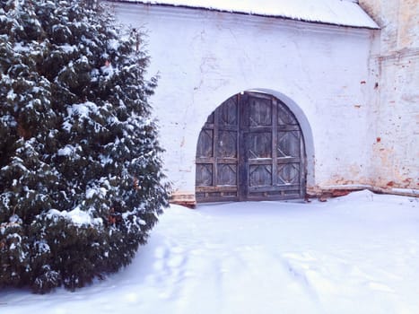 Old gate of monastery in winter. Lots of snow, Russia.