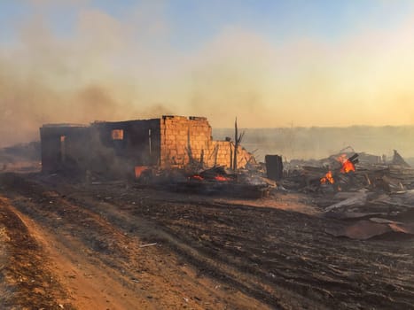 Building destroyed by fire. Flames and smoke still visible.