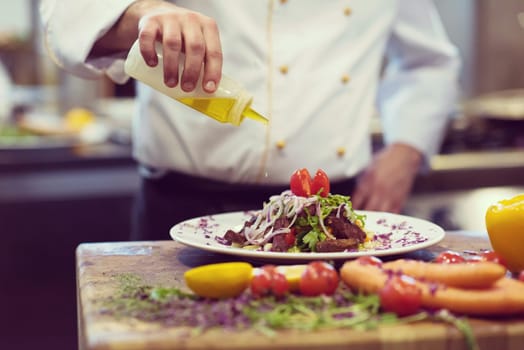 Chef finishing steak meat plate with Finally dish dressing and almost ready to serve at the table