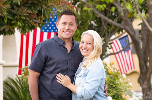 Happy Couple In Front of Houses with American Flags.