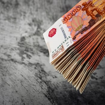 Russian rubles a large bundle on a gray background. A bundle of five-thousand-ruble notes. Place for logo, text, layout, mockup.