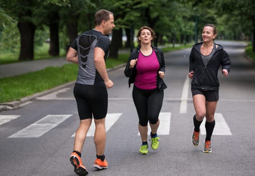 group of healthy people jogging in city park, runners team on morning training