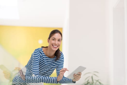 beautiful young woman at home websurfing on internet with tablet
