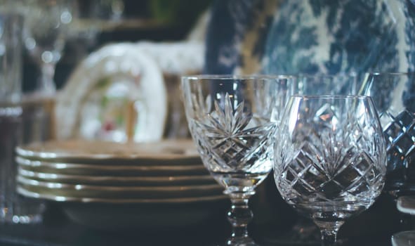 Set of Vintage crystal glasses on the black tray with Christmas decorations. Selective focus