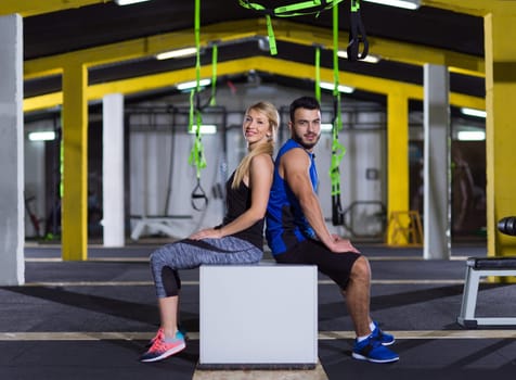 portrait of young healthy athletic people training jumping on fit box at gym