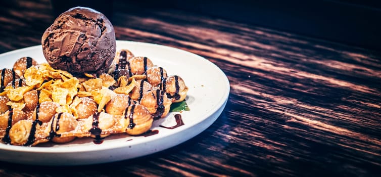 tasty pancakes with chocolate ice cream crispy waffle whipped cream with brownies cherry almond and chocolate syrup on top with corn-flex . summer holiday dessert Menu for kid  .