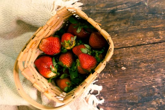 Strawberry in woven basket. Fresh strawberry. Red strawberry. Strawberry Juice. Wooden table background