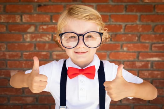 Cute Young Caucasian Boy With Thumbs Up Wearing Glasses and Red, White and Blue.
