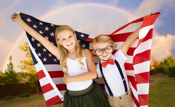 Cute Young Cuacasian Boy and Girl Holding American Flag With Rainbow Behind.