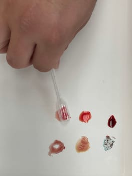 Medical doctor performing a quick blood group determination by using blood type testing kit with anti A and B antibodies on a white card. High quality photo