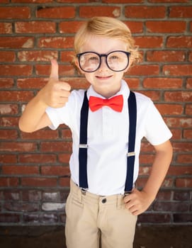 Cute Young Caucasian Boy With Thumbs Up Wearing Glasses and Red, White and Blue.
