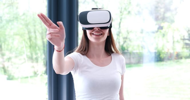 Smile happy woman getting experience using VR-headset glasses of virtual reality at home
