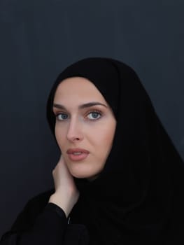 Portrait of modern young muslim woman in black abaya. Arab girl wearing traditional clothes and posing in front of black chalkboard. Representing modern and rich arabic lifestyle