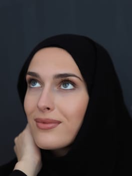 Portrait of modern young muslim woman in black abaya. Arab girl wearing traditional clothes and posing in front of black chalkboard. Representing modern and rich arabic lifestyle