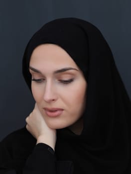 Portrait of modern young muslim woman in black abaya. Arab girl wearing traditional clothes and posing in front of black chalkboard. Representing modern and rich arabic lifestyle