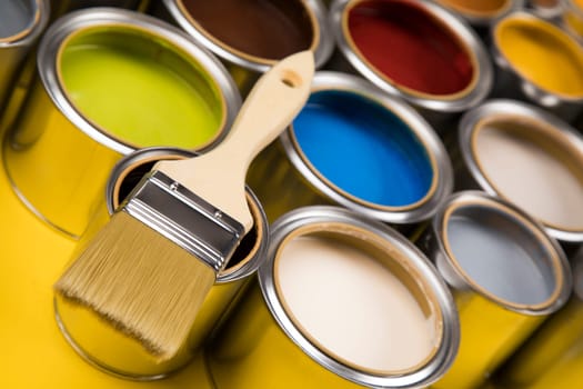 Tin cans with paint, brushes and bright palette of colors