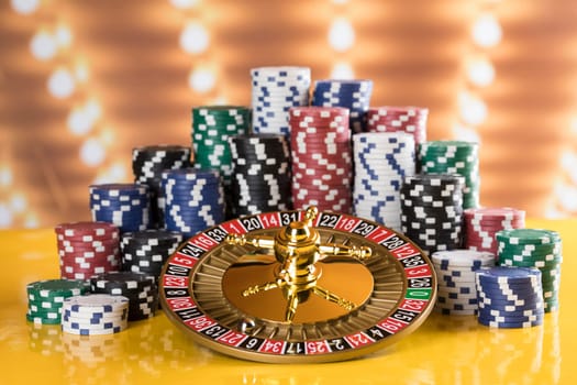 Poker Chips on gaming table, roulette wheel in motion, casino background