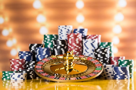 Poker Chips on gaming table, roulette wheel in motion, casino background