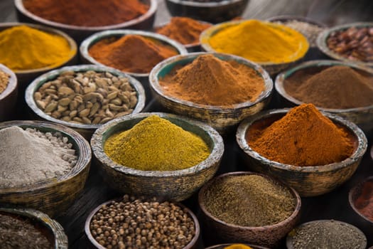 Assortment of spices in wooden bowl background