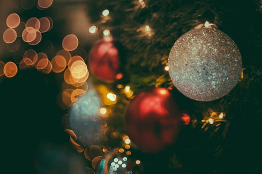 Selective focus Christmas tree with holiday silver disco balls and lights with copy space on blurred bokeh background.