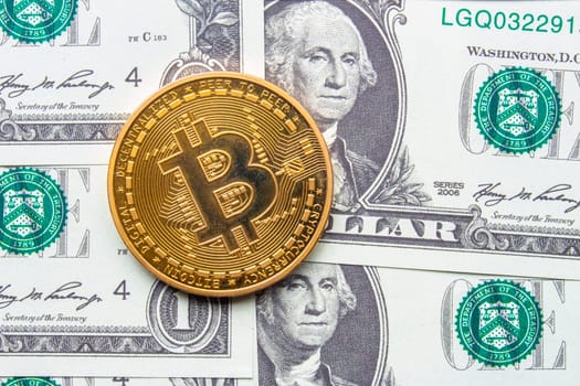 Calgary, Alberta, Canada. May 22, 2021. A Bitcoin with one dollar bills on the background.