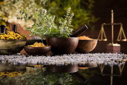Homeopathy, herbal medicine on wooden table , black mirror background