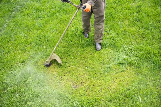 Mowing the grass with a lawn mower. Garden work concept background.