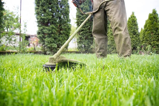 Mowing the grass with a lawn mower. Garden work concept background.