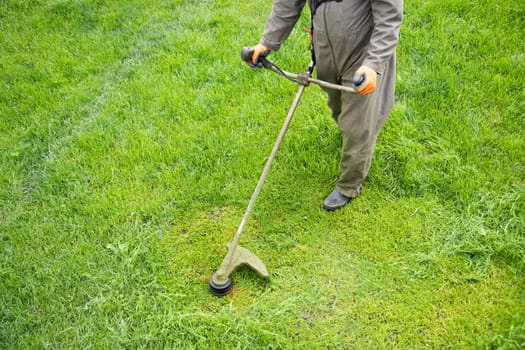 Mowing the grass with a lawn mower. Garden work concept background.