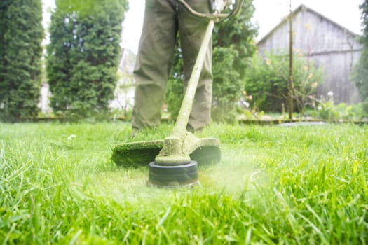 Mowing the grass with a lawn mower. Garden work concept background.