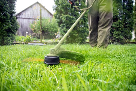 Mowing the grass with a lawn mower. Garden work concept background.