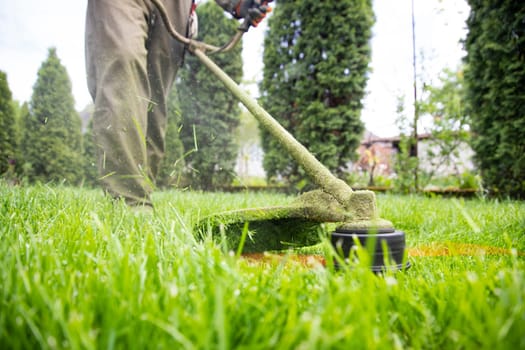 Mowing the grass with a lawn mower. Garden work concept background.