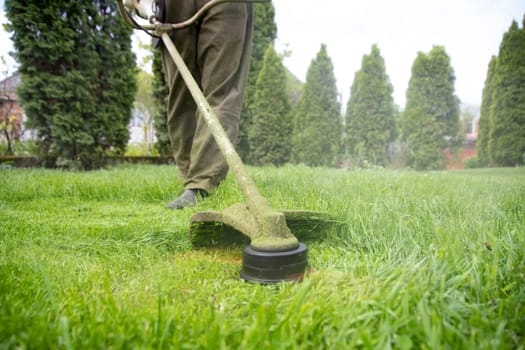 Mowing the grass with a lawn mower. Garden work concept background.