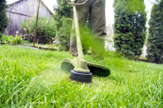 Mowing the grass with a lawn mower. Garden work concept background.
