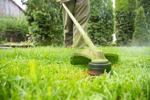 Mowing the grass with a lawn mower. Garden work concept background.