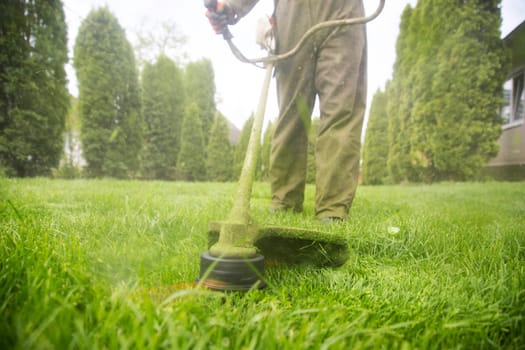 Mowing the grass with a lawn mower. Garden work concept background.