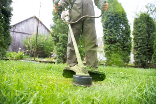 Mowing the grass with a lawn mower. Garden work concept background.