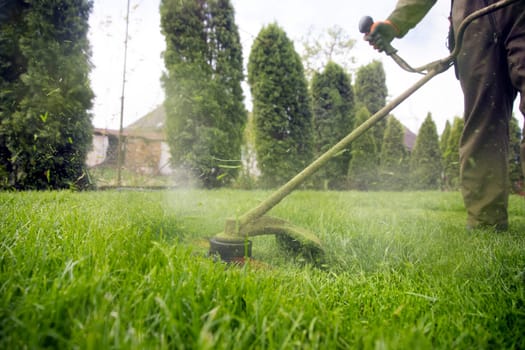 Mowing the grass with a lawn mower. Garden work concept background.