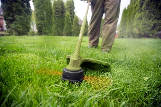 Mowing the grass with a lawn mower. Garden work concept background.