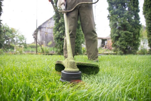Mowing the grass with a lawn mower. Garden work concept background.