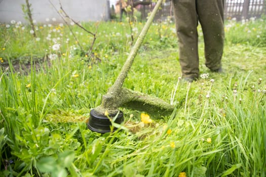 Mowing the grass with a lawn mower. Garden work concept background.