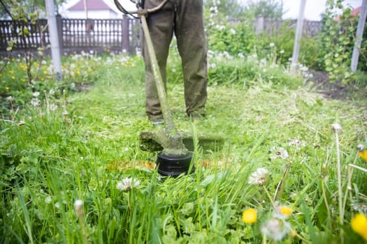Mowing the grass with a lawn mower. Garden work concept background.