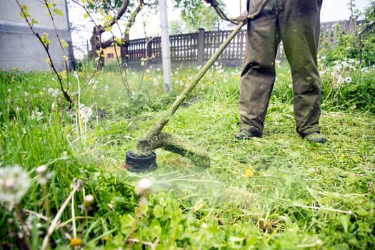 Mowing the grass with a lawn mower. Garden work concept background.