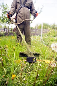 Mowing the grass with a lawn mower. Garden work concept background.