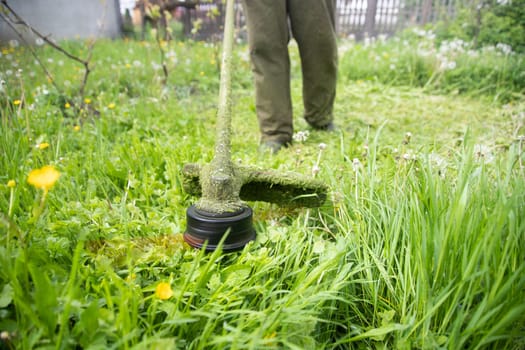 Mowing the grass with a lawn mower. Garden work concept background.