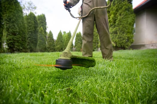 Mowing the grass with a lawn mower. Garden work concept background.