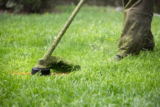 Mowing the grass with a lawn mower. Garden work concept background.