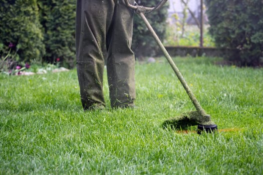 Mowing the grass with a lawn mower. Garden work concept background.