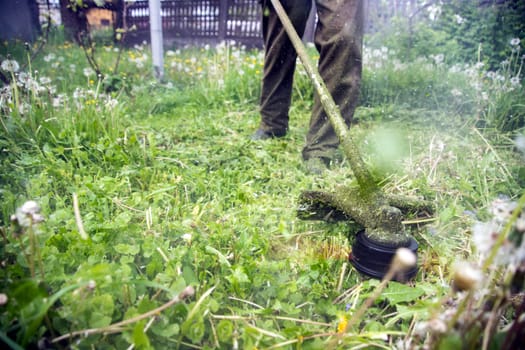 Mowing the grass with a lawn mower. Garden work concept background.